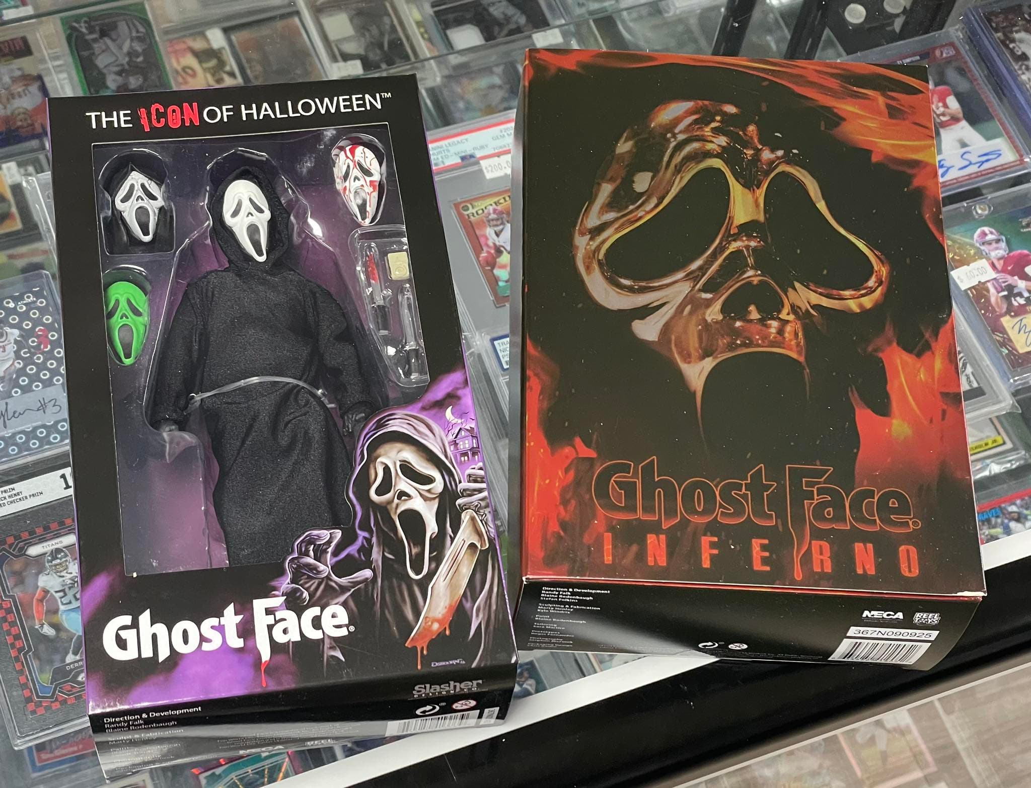 Ghost Face action figure box and Ghost Face Inferno box on a glass display case.